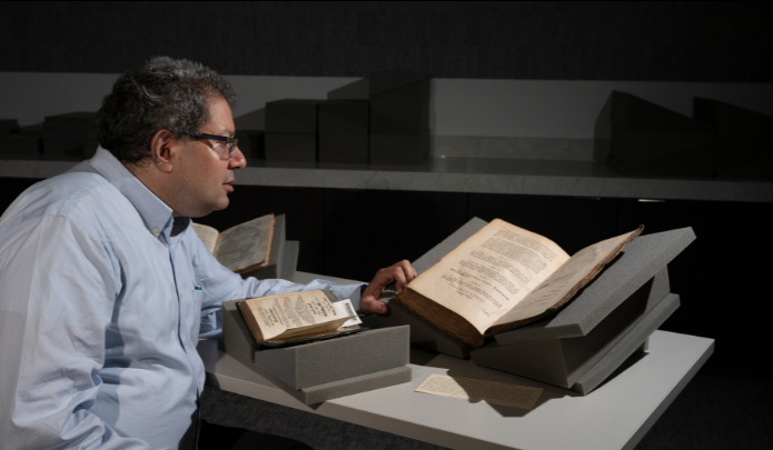 Adam Shear looking at open hebrew book