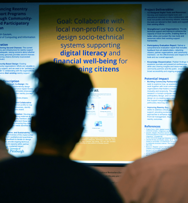people looking at a digital presentation at the Pitt Research Internal Funding Showcase