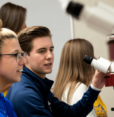 student at microscope