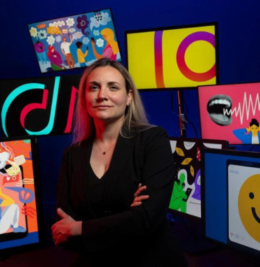 Sophia Choukas-Bradley standing in front of social media iconography
