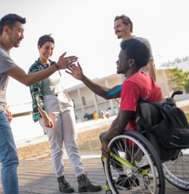 person in wheelchair high fiving someone