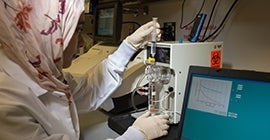 Woman examining laboratory equipment and charts
